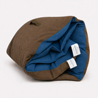 Rolled Cozie Dozie Co. Joey adventure lounger cover in deep BowerBird Blue French linen with brown canvas backing.