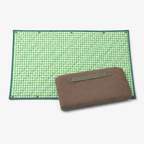 Quilted Cozie Dozie Co. Co-mpanion Swag Mat in green gingham displayed flat alongside its folded brown canvas carry case with webbing handle against a white background.