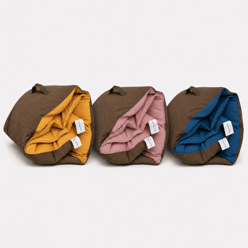 Three rolled Cozie Dozie Co. Colour of Country Joey adventure loungers lined up in Ochre, Quartz, and BowerBird Blue with brown canvas backing.