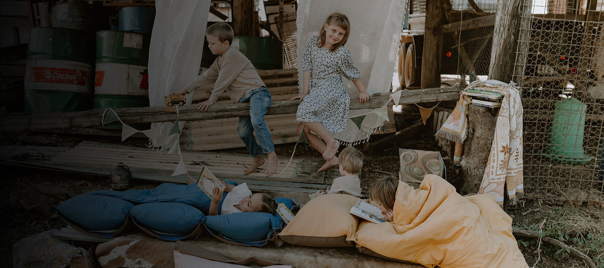 Children playing and resting on Cozie Dozie Co. adventure loungers inside a decorated rustic barn during a Cozie Dozie Littles country sparkle experience.